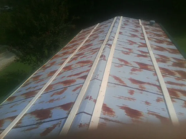 Rusted metal roof panels with new wood purlins before replacement — Storm Damage Roof Repair in New Lisbon by Roofing Brothers